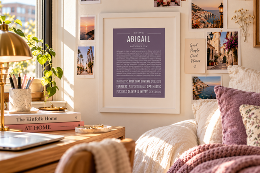 Framed Abigail name art in a bright, cozy college dorm room with books, travel photos and warm sunlight.