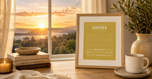 Framed Aurora Name Stories print displayed beside a window at sunrise, with warm golden light, books on Greek and Roman mythology, and cozy neutral décor.