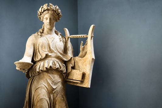 Classical marble statue of Calliope, the Greek muse of epic poetry, holding a lyre and scroll against a soft blue background.