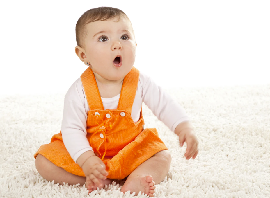 Baby in orange overalls looking free-spirited like the meaning of Charlotte
