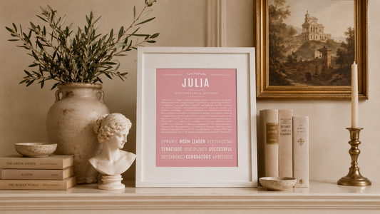 Julia name meaning art print in blush pink displayed in a styled interior with Roman decor, classical bust sculpture, antique books, and warm neutral tones.