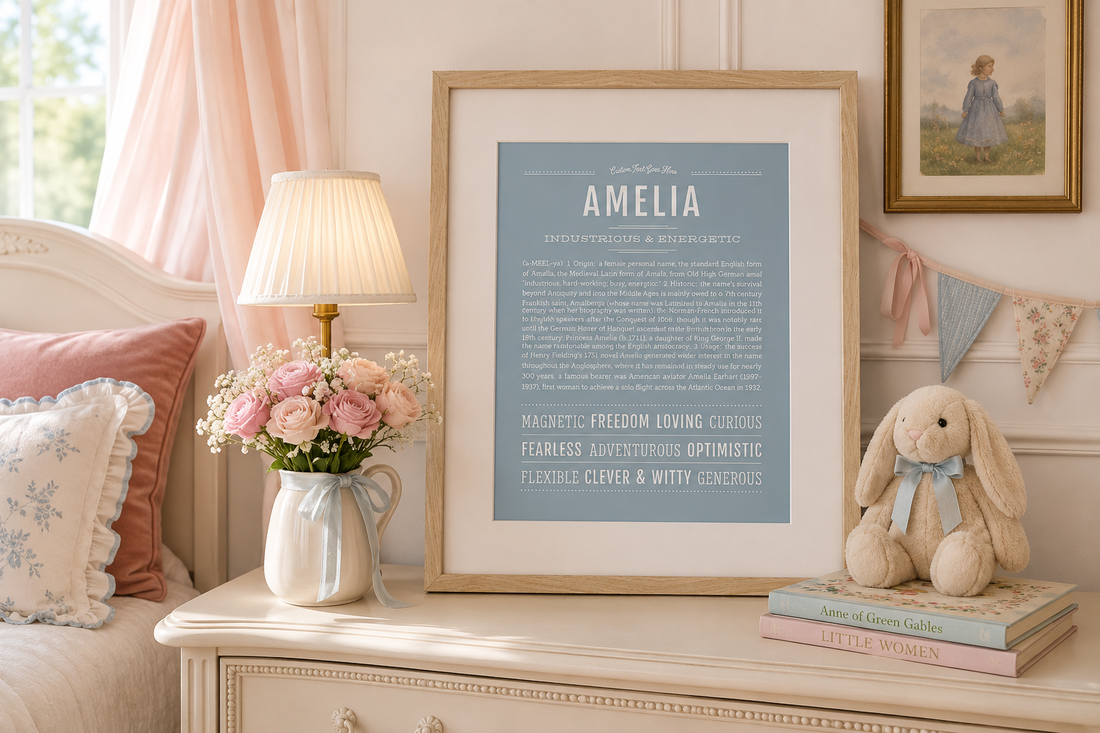 Framed Amelia Name Stories® art print in a soft blue design displayed in an elegant blush-and-blue nursery with flowers, books, and vintage decor.