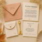 Personalized stationery gift set featuring a peach envelope with gold foil text, a cream fabric pouch with a gold snap, a gold key, and two custom cards on a neutral beige background with autumn-themed props.